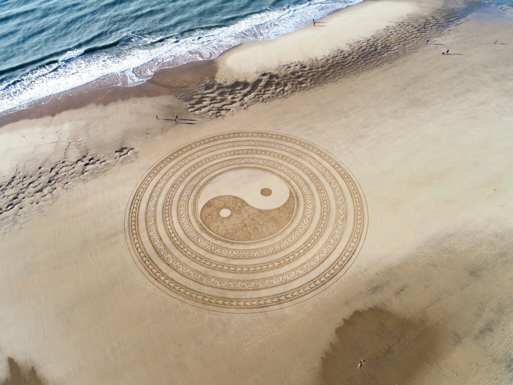 yin yang symbol on brown beach sand